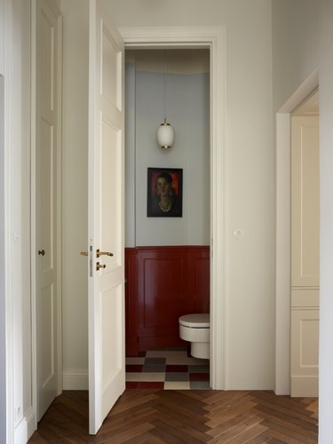 open door leading to bathroom with maroon paint on bottom half of walls