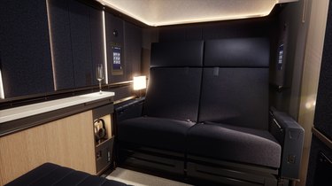 A black leather loveseat built into a room on an airplane