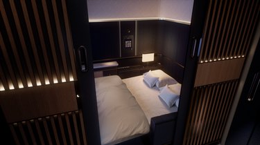 A double bed in a small room on an airplane.