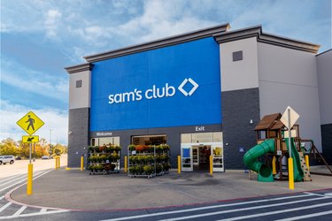 A Sam's Club exterior with a blue painted front and a jungle gym on the sidewalk.