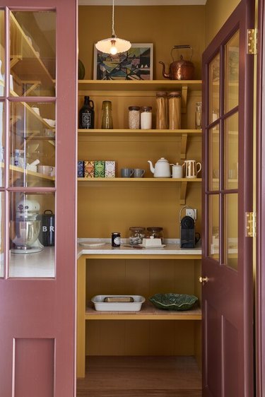 Pantry with maroon doors and yellow interior.