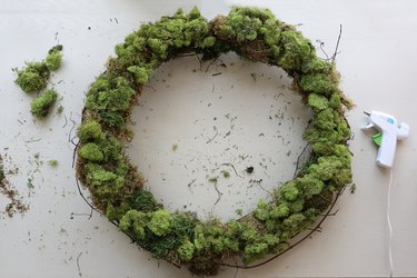 Gluing reindeer moss to wreath