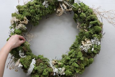 Gluing reindeer moss to inner rim of wreath