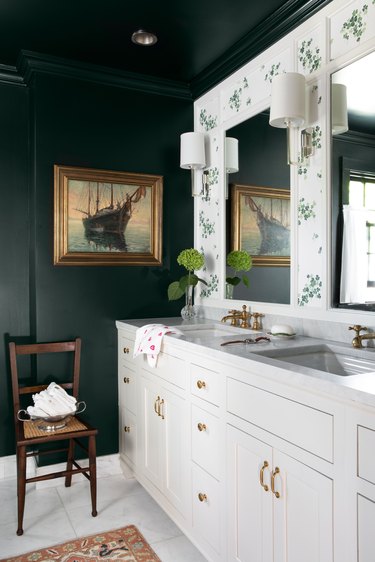 White bathroom cabinets with forest green-painted walls