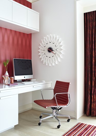 Office with white walls and furniture and red wallpaper and accessories