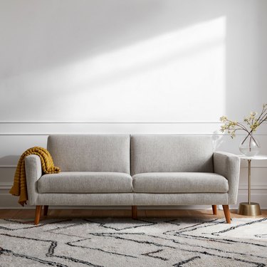 taupe-colored loveseat with slanted legs