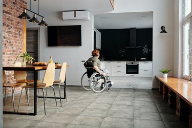 woman in wheelchair moving through apartment