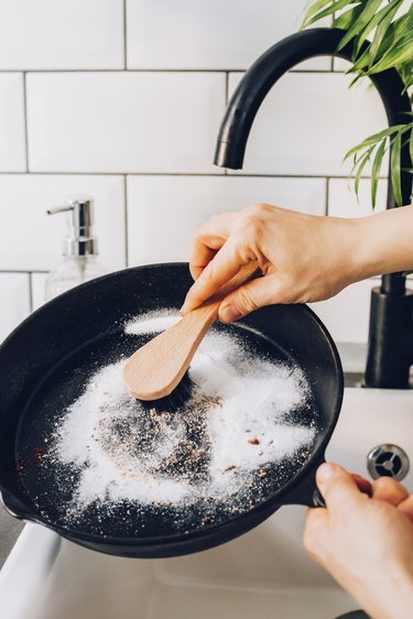 Scrub skillet with baking soda and stiff brush