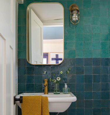 coastal bathroom with turquoise and teal zellige tile wall and brass accents