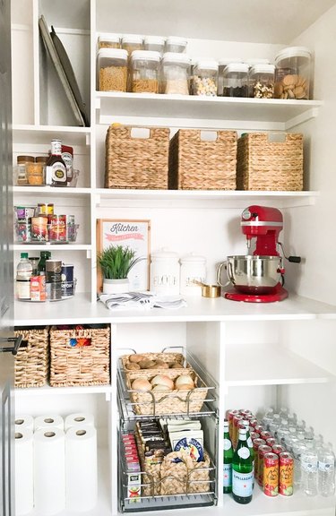 Pantry with shelves, baskets, mixer, supplies.