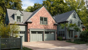 Brick house with sage green trim and garage doors