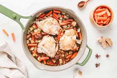 Chicken and liquids in a green skillet