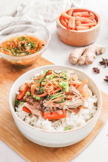 Postpartum chicken in a bowl with pickled vegetables on top