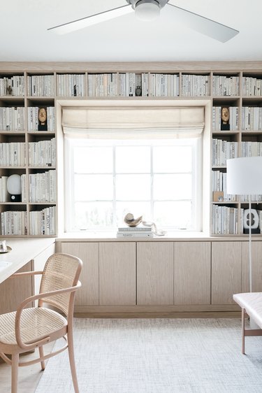 neutral home office with bookshelves and wood cabinets