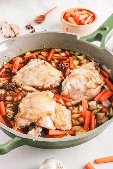 Chicken, vegetables, and broth in a pan