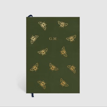 green notebook with gold foil bees