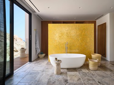contemporary minimalist bathroom with yellow zellige tiled floating wall