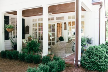 outdoor patio with wicker chairs and tall columns