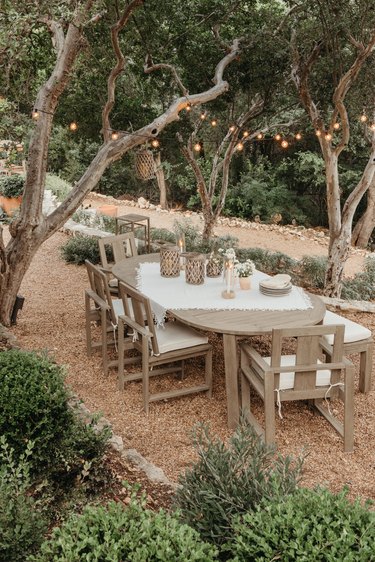 coastal grandmother decor idea for patio covered in gravel with dining table setup