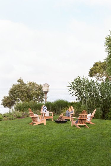 coastal grandmother decor idea for patio covered in grass with adirondack chairs