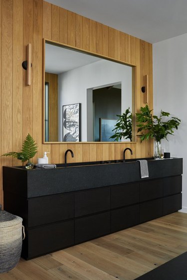 rustic bathroom with black sink and vanity and wood walls