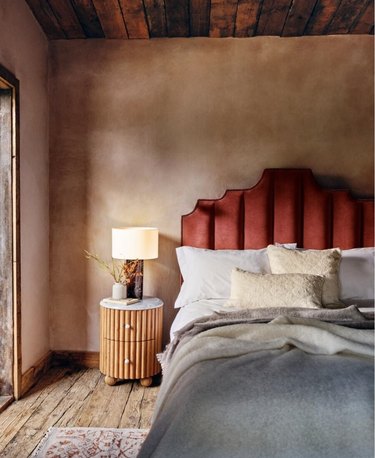bedroom with rust headboard and limewashed pink walls