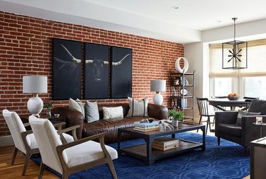brown leather sofa against a brick wall