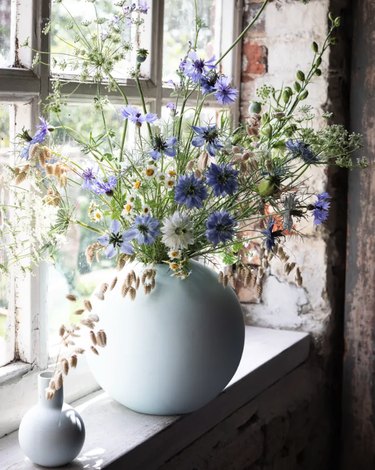 summer flower arrangement idea with wild flowers in vase near window