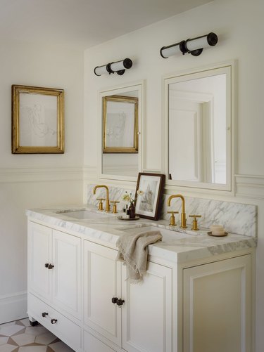 all white bathroom with gold and oil rubbed bronze hardware