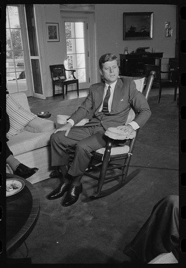 presdeint john f kennedy in a rocking chair in the white house