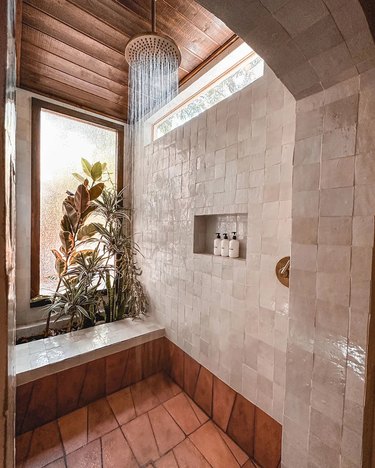 walk in shower with zellige tile walls and shower bench and shelving niche