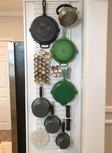 Spices, pots and pans organized on peg board.
