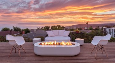 Deck with modern fire pit, chairs, couch.