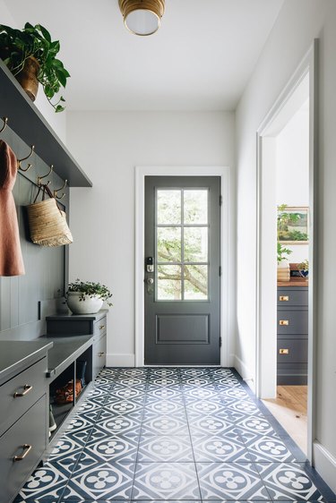 mudroom with navy floor tile and gray millwork