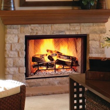 A prefabricated wood-burning fireplace with a stone surround