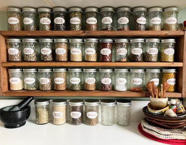 Spice rack with preserve jars and labels.