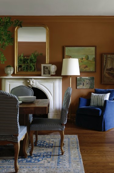 living room with rust walls and cobalt club chair