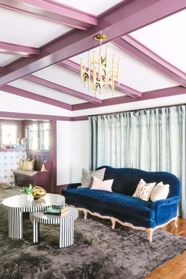 white living room with mauve accent wooden beams and royal blue sofa