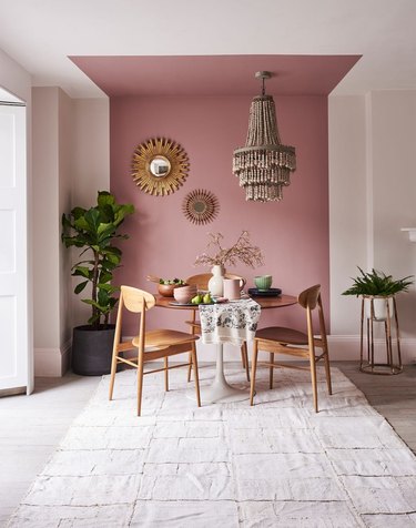 off-white dining room with mauve block on wall and ceiling, finished with natural furniture and decor