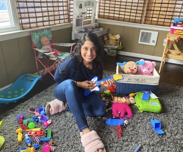 photo of Mamta Patel Nagaraja in playroom holding toy guitar