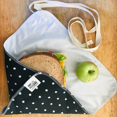 Sandwich and apple on a black and white polka dot fabric wrap