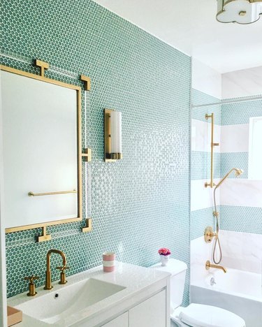 penny tile bathroom with blue green penny tile wall and cabana stripe shower with gold hardware