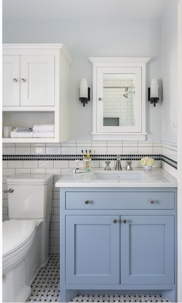 traditional blue and white bathroom with basketweave tile floor adn white tile wainscoting with penny tile accent strip