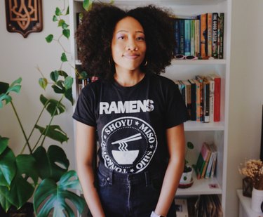 photo of Jenay Ross near a plant and bookshelf