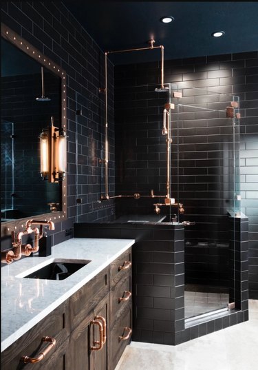 black bathroom with copper hardware