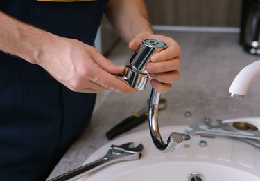 person reassembling faucet