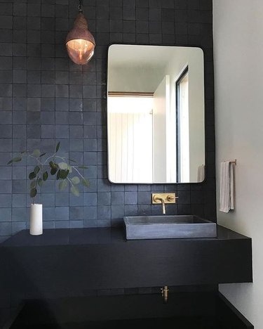 all black bathroom with tile backsplash and floating vanity