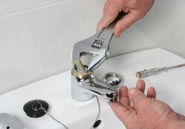 plumber servicing the valve of a faucet