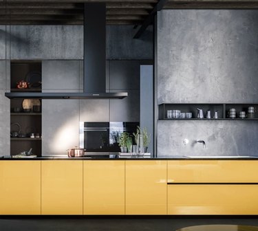 Kitchen with yellow cabinets, black appliances.