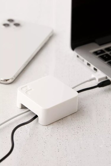 minimalist white cable organizer on white desk